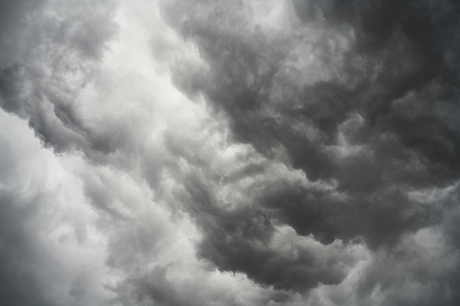 Moody and dramatic storm clouds forming in a turbulent overcast sky.