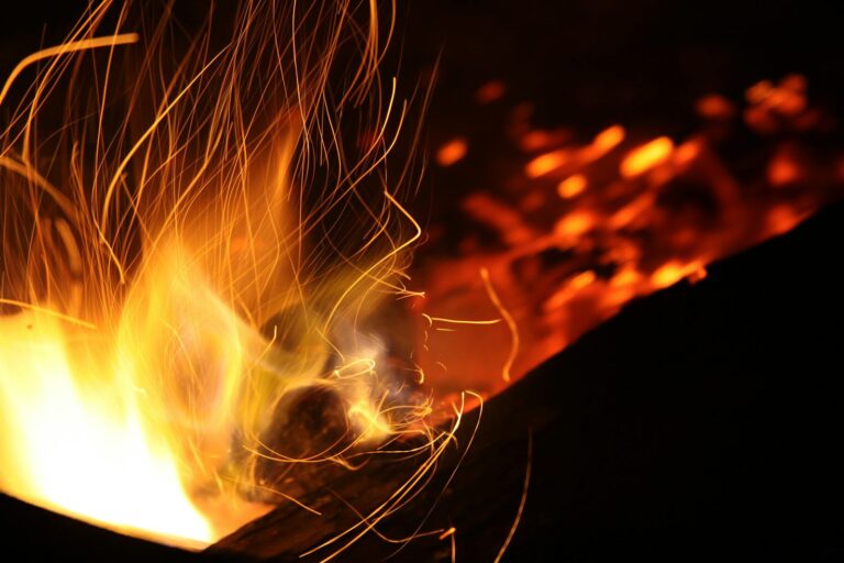 Long exposure shot of dynamic flames and sparks creating a warm atmosphere at night.