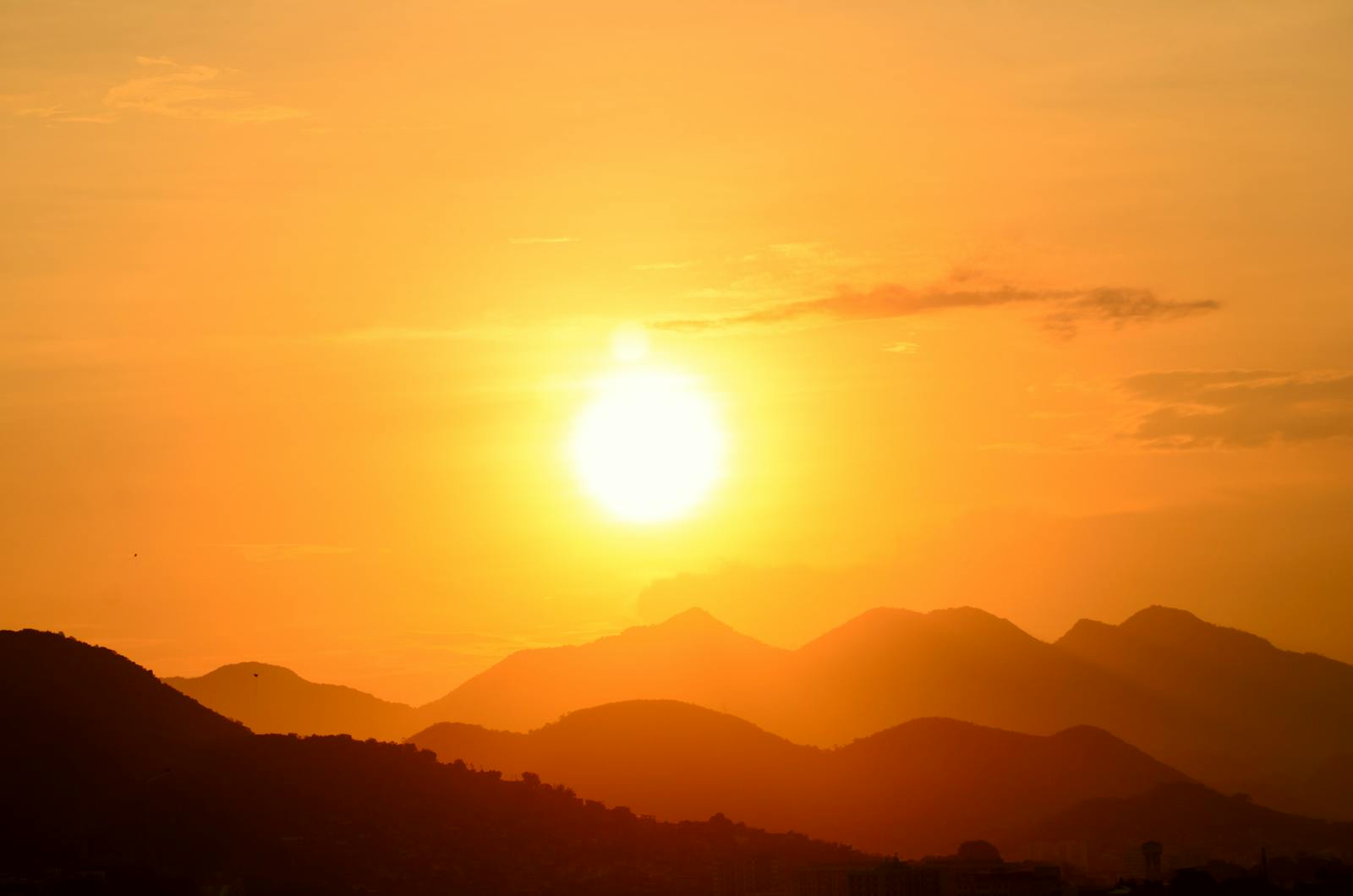 Stunning sunset over Rio de Janeiro's mountains, capturing the vibrant golden hues and silhouettes.