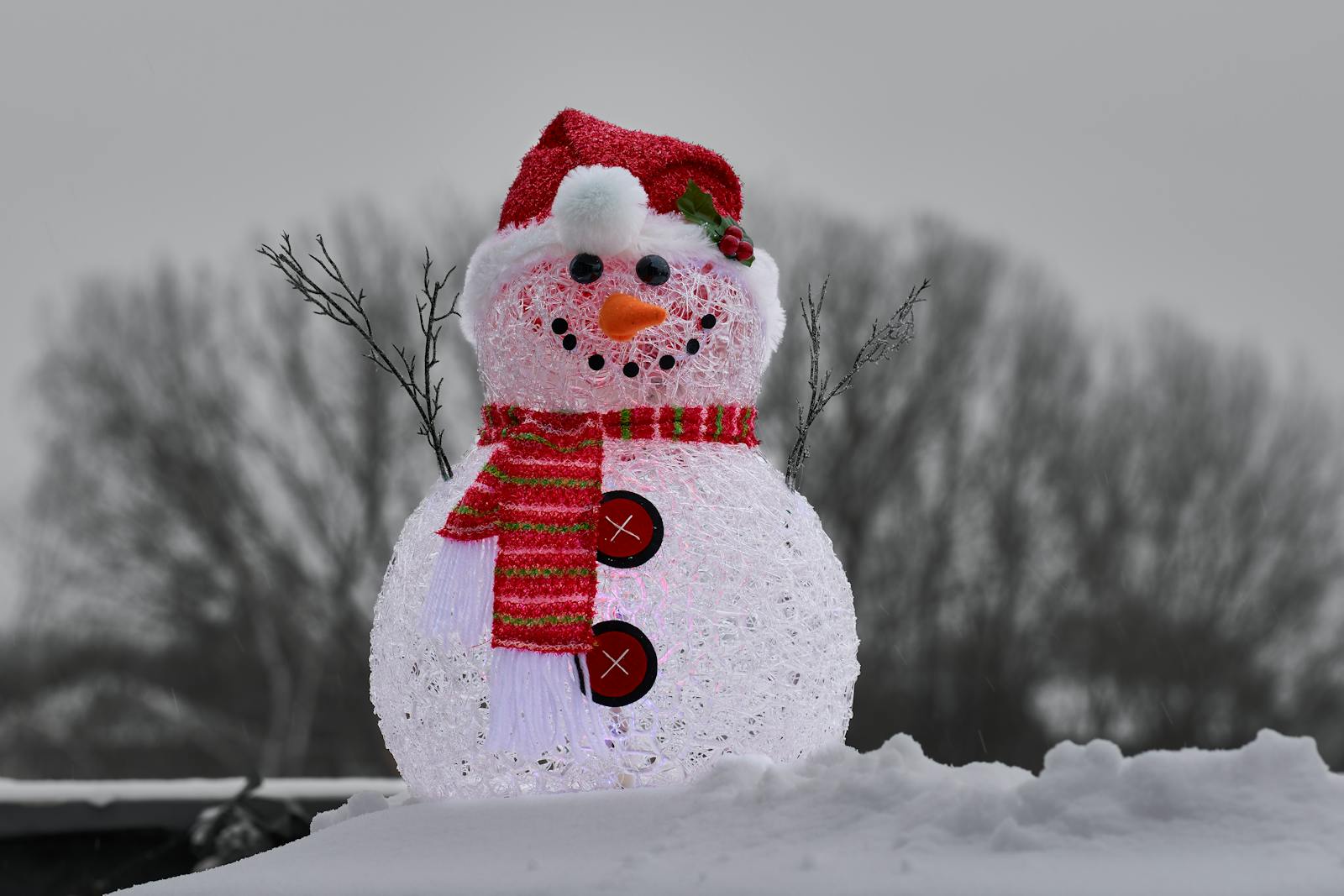 Glistening snowman with scarf and hat in a snowy winter scene.